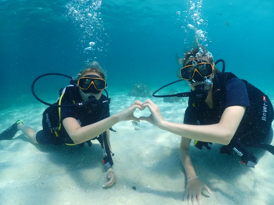 Dos buceadores formando un corazón bajo el agua