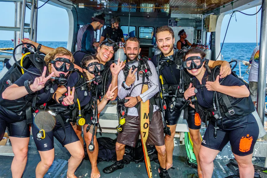 Grupo de bautizo de buceo celebrando en el barco