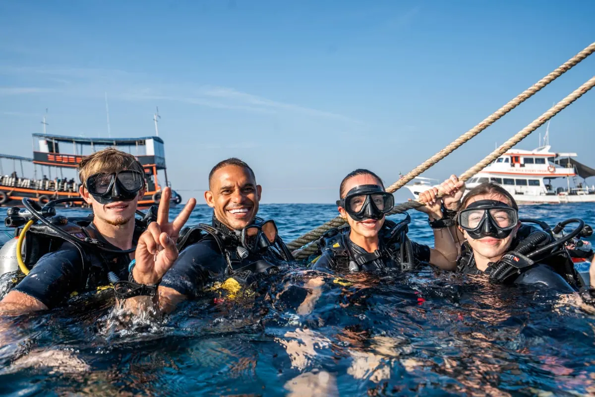 Candidatos a Divemaster en la superficie junto al barco, listos para descender