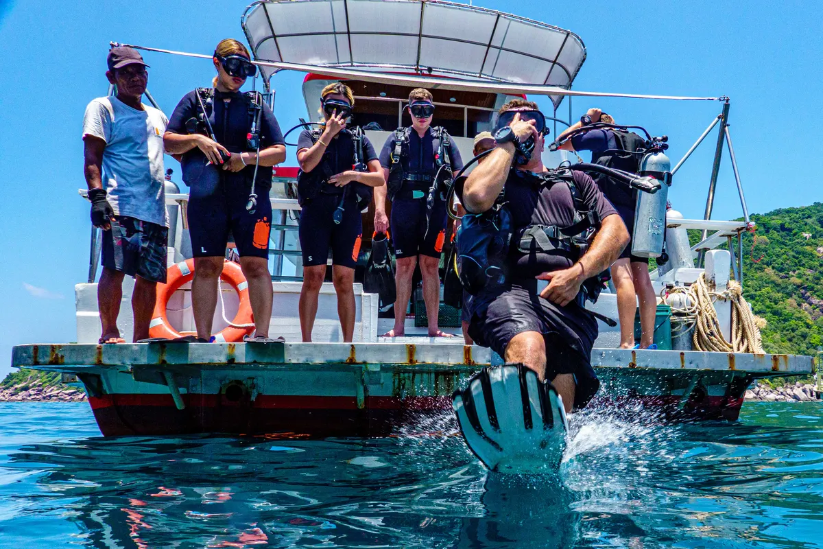 Candidato a Divemaster saltando desde la plataforma del barco ante el equipo