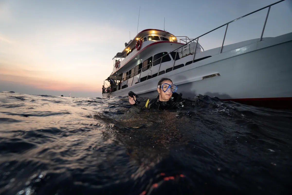 Buceadora en superficie junto al barco al caer la noche
