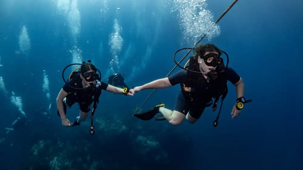 An instructor and student on an advanced diving course in Koh Tao, practising skills mid-water above the reef