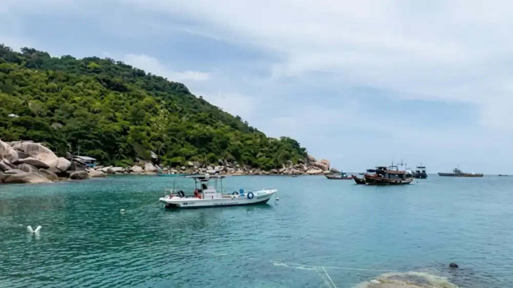 Hin Wong Bay on Koh Tao's northeast coast, a pebble beach surrounded by huge granite boulders and emerald-green water