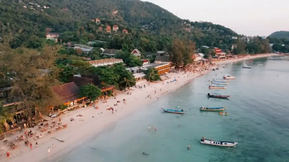 Sairee Beach at sunset, with beach bars, palm trees and longtail boats along Koh Tao's longest stretch of sand