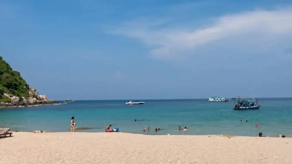 Aow Leuk bay on Koh Tao, calm shallow water over sand and coral with rocky headlands on either side