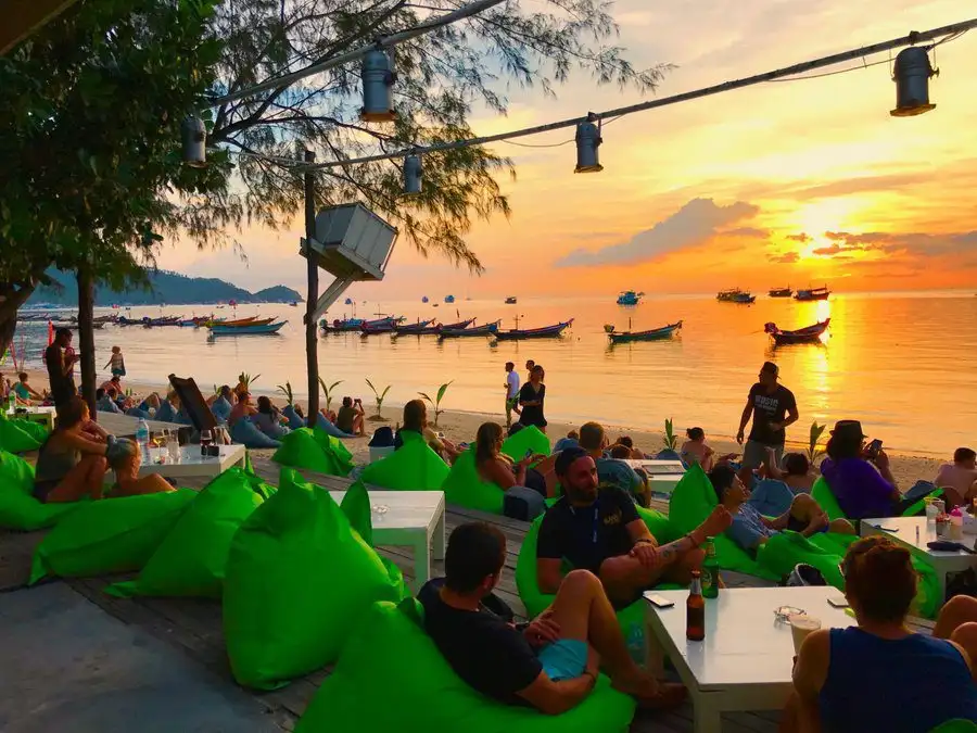 Beanbags and low tables on the sand at Fizz Beachlounge on Sairee Beach as the sun goes down