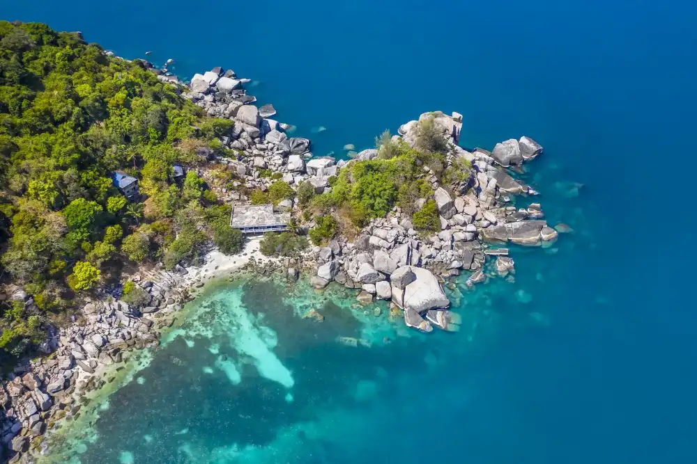 Laem Thian Bay on Koh Tao's east coast, with rocky reef formations and boulders rising out of clear water