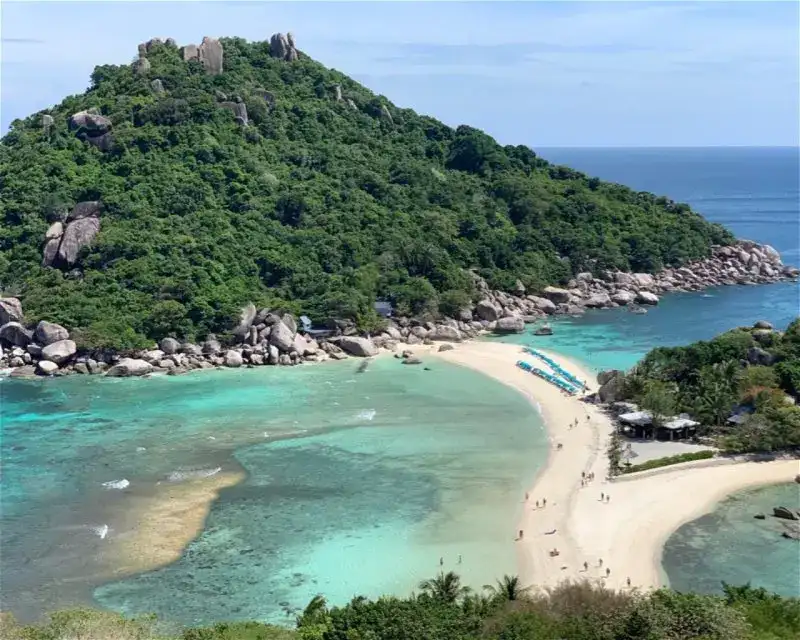Divers exploring the coral-covered boulders and pinnacles of Twins dive site, south of Koh Nang Yuan