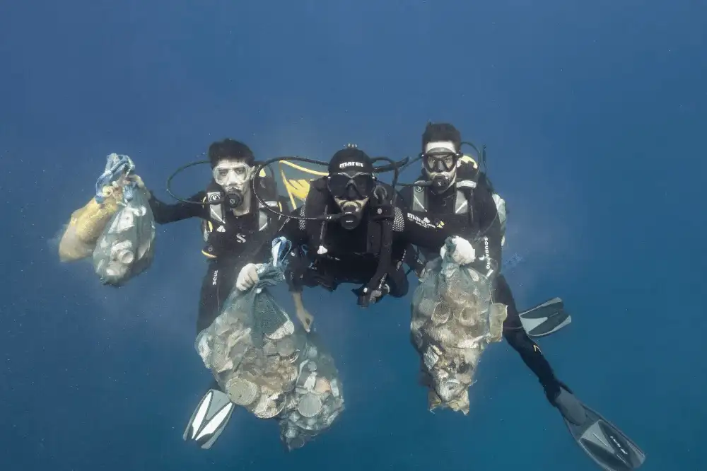 A diver hovering above a healthy coral reef in the clear waters of Koh Tao, practising good buoyancy to avoid touching the coral