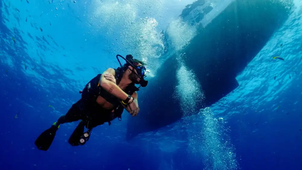 A professional diving instructor teaching students in the shallow water off Koh Tao