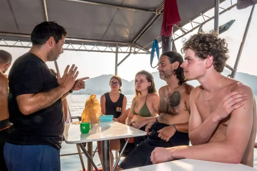 A line-up of scuba diving instructors in wetsuits standing side by side, as if in a police line-up