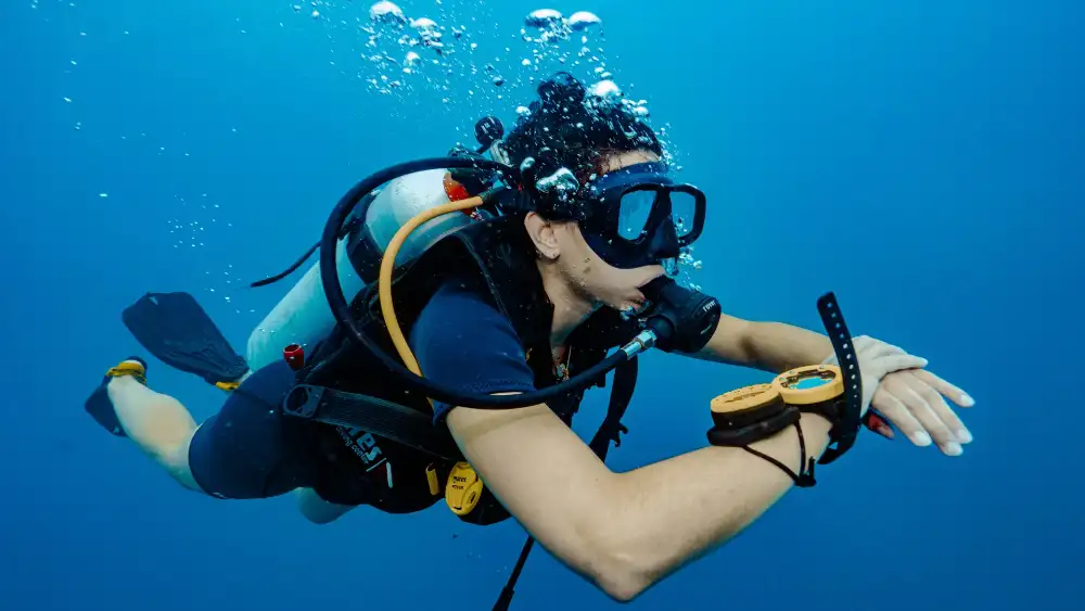 An Open Water student and instructor practising scuba skills in the shallow, clear water off Koh Tao