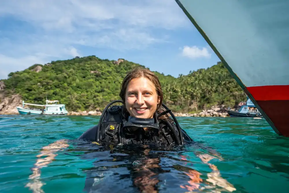 Open Water students in full scuba gear on a La Bombona Diving boat off Koh Tao, ready for a training dive