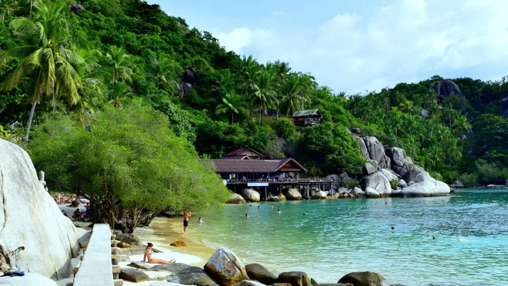 Transport options for getting to Koh Tao: a ferry at sea with the island coastline behind