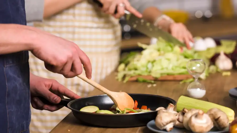 Travellers preparing Thai dishes together at a cooking class in Koh Tao
