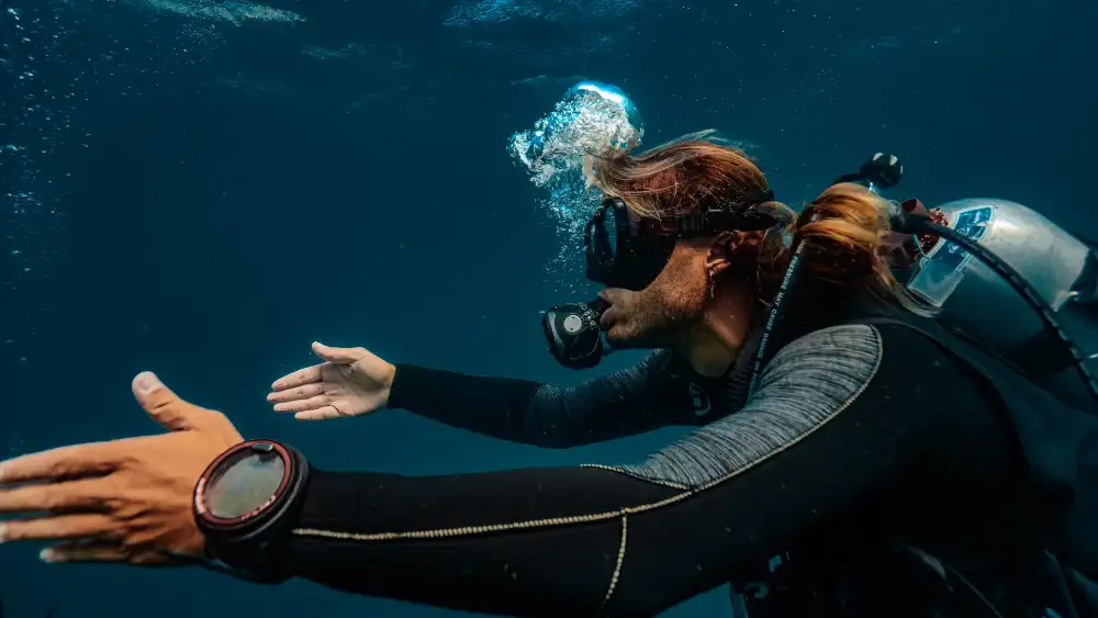 A scuba diving student and instructor underwater on a Koh Tao reef during an Open Water course