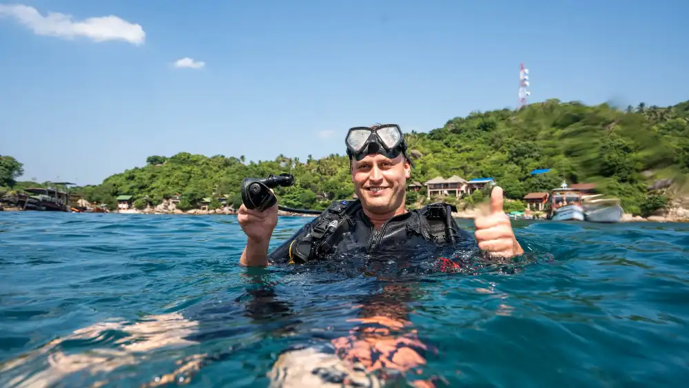 Certified divers on a guided fun dive exploring a coral pinnacle off Koh Tao