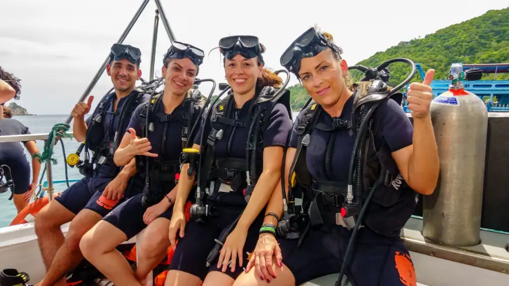 Two divers hovering over a coral reef on Koh Tao, comparing SSI and RAID certification training