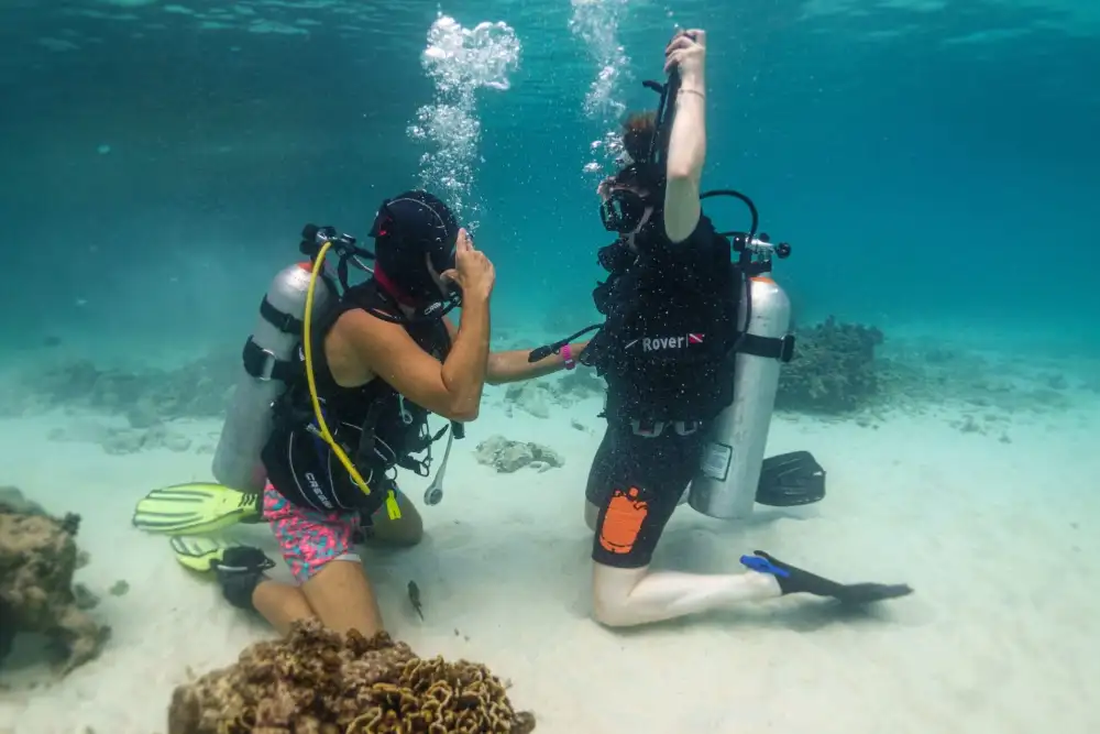 A first-time diver and their instructor underwater over a shallow reef in Koh Tao during a try dive